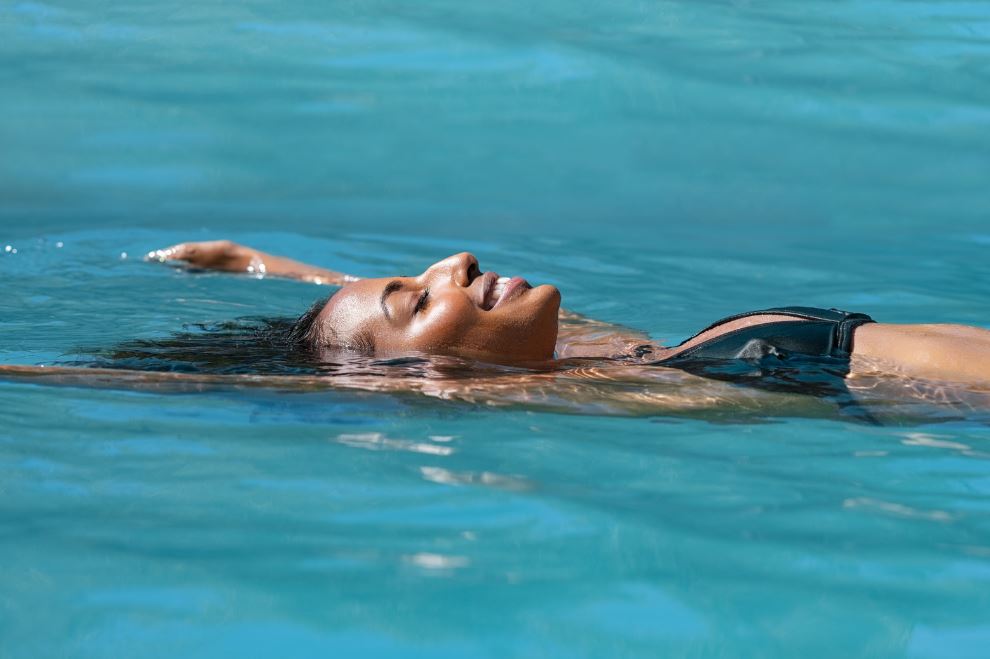 Woman floating in Grand Bay hotel pool relaxing
